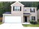 Charming two-story home featuring a brick facade, attached two-car garage, black shutters, and landscaped yard at 5626 Laurel Ridge Dr, Atlanta, GA 30344