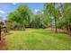 Expansive backyard featuring a well-maintained lawn, mature trees, and a fun playset for outdoor activities at 730 Mount Oglethorpe Trl, Alpharetta, GA 30022