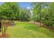 Large backyard with lush green grass, mature trees, and a charming playset, perfect for Gathering fun at 730 Mount Oglethorpe Trl, Alpharetta, GA 30022