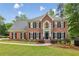 Beautiful two story brick home with a landscaped yard, black shutters and trimmed bushes in front at 730 Mount Oglethorpe Trl, Alpharetta, GA 30022