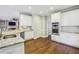 Modern white kitchen featuring granite countertops, stainless steel appliances, and wood floors at 730 Mount Oglethorpe Trl, Alpharetta, GA 30022