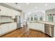 Bright white kitchen with stainless steel appliances, granite counters, and hardwood floors at 730 Mount Oglethorpe Trl, Alpharetta, GA 30022