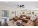 Open living room featuring a leather sectional sofa, ceiling fan, wood floors, and neutral paint at 730 Mount Oglethorpe Trl, Alpharetta, GA 30022