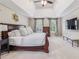 Spacious main bedroom with a tray ceiling, large windows and a wall mounted television at 730 Mount Oglethorpe Trl, Alpharetta, GA 30022
