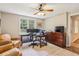 Comfortable office space featuring hardwood desk, ceiling fan, and large window overlooking landscaped yard at 730 Mount Oglethorpe Trl, Alpharetta, GA 30022