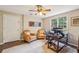 Office with two chairs, a computer desk, hardwood floors, a ceiling fan, and a large window overlooking the backyard at 730 Mount Oglethorpe Trl, Alpharetta, GA 30022
