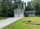 Charming home featuring a two-car garage, well-manicured lawn, and mature trees at 7562 Asbury Manor Dr, Lithonia, GA 30014