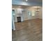 Bright kitchen and dining area featuring new flooring, white cabinets, and stainless steel dishwasher at 7562 Asbury Manor Dr, Lithonia, GA 30014