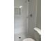 Bright white tiled shower with a built-in niche and modern fixtures at 7562 Asbury Manor Dr, Lithonia, GA 30014