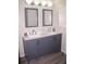 Bathroom featuring a double sink vanity with gray cabinets, white countertop, and two framed mirrors at 4190 Wingfoot Ct, Decatur, GA 30035