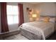 Bedroom with a large window, neutral walls, stylish décor, a cozy bed, and a warm ambiance at 4190 Wingfoot Ct, Decatur, GA 30035