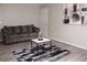Living room featuring a gray couch, neutral paint, modern art, and black/gray rug at 4190 Wingfoot Ct, Decatur, GA 30035