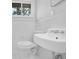 The all-white bathroom features a sink and a toilet with a window nearby at 4222 Webb Rd, Tucker, GA 30084