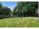 View of the home's large, grassy backyard with a fenced perimeter and a stone fire pit at 1265 Birchwood Ln, Roswell, GA 30076