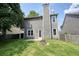 View of the home's large, grassy backyard with a fenced perimeter and a stone fire pit at 1265 Birchwood Ln, Roswell, GA 30076
