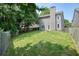 View of the home's large, grassy backyard with a fenced perimeter and a stone fire pit at 1265 Birchwood Ln, Roswell, GA 30076