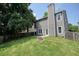 View of the home's large, grassy backyard with a fenced perimeter and a stone fire pit at 1265 Birchwood Ln, Roswell, GA 30076