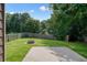 Manicured backyard with lush grass, concrete patio, and wood fence at 1265 Birchwood Ln, Roswell, GA 30076