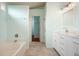 Bright bathroom featuring a bathtub, vanity with marble top, and tile flooring at 1265 Birchwood Ln, Roswell, GA 30076