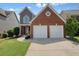 Charming two-story home with a red brick and gray siding, with a two-car garage and well-maintained lawn at 1265 Birchwood Ln, Roswell, GA 30076