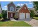 Charming two-story home with a red brick and gray siding, with a two-car garage and well-maintained lawn at 1265 Birchwood Ln, Roswell, GA 30076