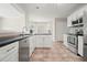Bright kitchen features stainless steel appliances, ample storage, and granite countertops at 1265 Birchwood Ln, Roswell, GA 30076