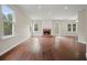Spacious living room featuring gleaming hardwood floors, a cozy fireplace, and plenty of natural light at 1265 Birchwood Ln, Roswell, GA 30076