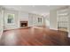 Bright living room with hardwood floors and a brick fireplace, complemented by natural light from large windows at 1265 Birchwood Ln, Roswell, GA 30076