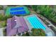 Aerial view of a community pool and tennis courts surrounded by mature trees and manicured landscaping at 2325 Lake Cove Ct, Buford, GA 30519