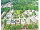 Aerial view of a home nestled in a lush, green community with mature trees and a small lake at 2325 Lake Cove Ct, Buford, GA 30519