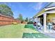 Landscaped backyard features a covered patio, a well-manicured lawn, and a wood fence for privacy at 2325 Lake Cove Ct, Buford, GA 30519