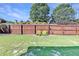 Fenced backyard with well-maintained lawn, mature trees, and manicured landscaping provides privacy at 2325 Lake Cove Ct, Buford, GA 30519