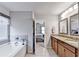 Bathroom with double sinks, bathtub and shower, tile flooring, and decorative mirrors at 2325 Lake Cove Ct, Buford, GA 30519