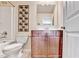 Bright bathroom with a shower-tub combo, stylish vanity with wood cabinets and decorative wall art at 2325 Lake Cove Ct, Buford, GA 30519