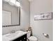 Stylish powder room with modern fixtures, decorative mirror, bird artwork, and a vessel sink at 2325 Lake Cove Ct, Buford, GA 30519