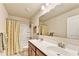 Bathroom with double sink vanity and tub shower featuring decorative curtain and mirror at 2325 Lake Cove Ct, Buford, GA 30519