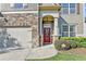 Inviting home exterior featuring a stone facade, red front door with wreath, and well-maintained landscaping at 2325 Lake Cove Ct, Buford, GA 30519