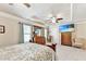 Bright main bedroom with tray ceiling, TV, wooden furniture, carpet, and a fan at 2325 Lake Cove Ct, Buford, GA 30519