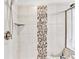 Walk in shower with stone tiling and stylish mosaic tile detailing at 2325 Lake Cove Ct, Buford, GA 30519