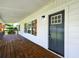 View of covered front porch featuring wood decking and shutters, and black front door at 5619 Beaver Sw Dr, Mableton, GA 30126