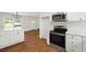 Open-concept kitchen featuring stainless steel appliances, hardwood floors, breakfast bar, and natural light at 5619 Beaver Sw Dr, Mableton, GA 30126
