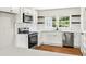 Bright kitchen featuring white cabinets, stainless steel appliances, hardwood floors, and subway tile backsplash at 5619 Beaver Sw Dr, Mableton, GA 30126
