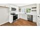 Beautiful kitchen with stainless steel appliances, wood floors, white cabinets, floating shelves and backsplash at 5619 Beaver Sw Dr, Mableton, GA 30126