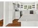 Bright, white kitchen featuring stone countertops, stainless steel appliances, and dark hardwood floors at 5619 Beaver Sw Dr, Mableton, GA 30126