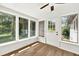 Bright sunroom featuring a ceiling fan, wood-look floors, and windows overlooking the backyard at 5619 Beaver Sw Dr, Mableton, GA 30126
