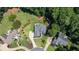 An aerial view of the home reveals mature trees, a lush green lawn, and a large circular driveway at 619 Lovinggood Trl, Woodstock, GA 30189
