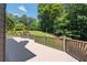 Expansive backyard view from the wooden deck, featuring a well-manicured lawn and mature trees at 619 Lovinggood Trl, Woodstock, GA 30189