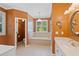 Warm toned primary bath with soaking tub, double vanity and natural light at 619 Lovinggood Trl, Woodstock, GA 30189