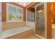 Bathroom featuring a soaking tub by the window, and a separate glass shower at 619 Lovinggood Trl, Woodstock, GA 30189