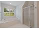 Bright bathroom features soaking tub under window, and a glass shower at 619 Lovinggood Trl, Woodstock, GA 30189
